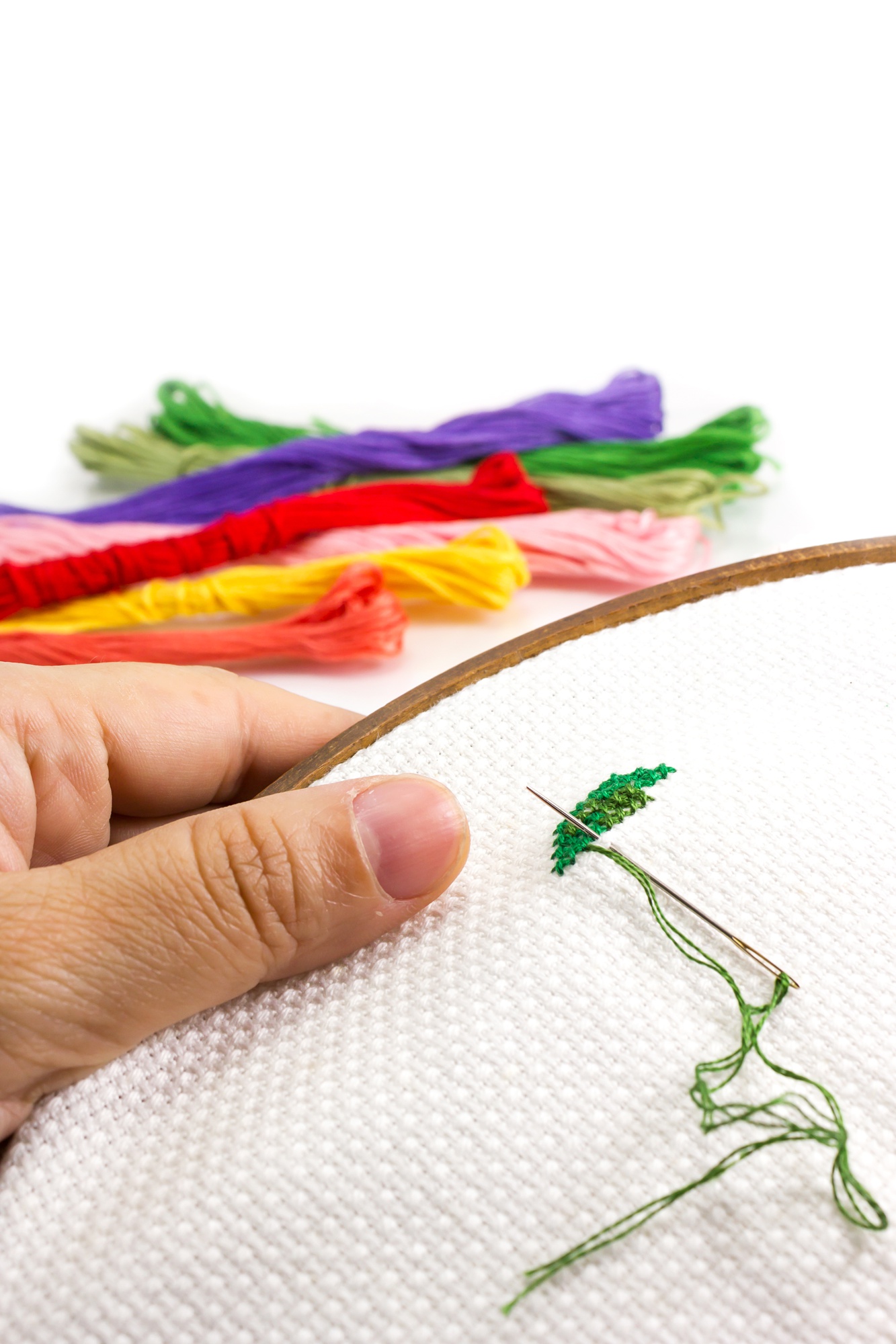 Artisan hands embroidering floral pattern